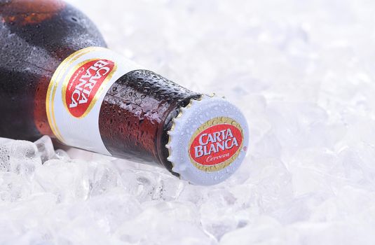 IRVINE, CA - JANUARY 11, 2015: A bottle of Carta Blanca Beer, closeup on a bed of ice. From Cerveceria Cuauhtemoc-Moctezuma, founded in 1890, now a subsidiary of Heineken International.