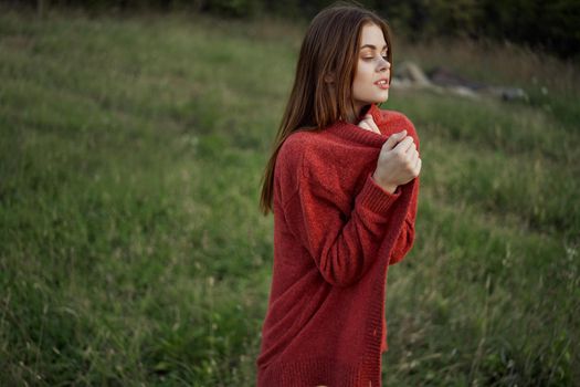 woman outdoors in a red sweater cool nature. High quality photo
