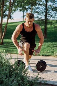 athletic man with dumbbells workout outdoors motivation. High quality photo