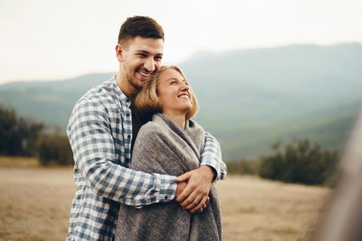 Happy loving couple hiking and hugging in mountains, close up