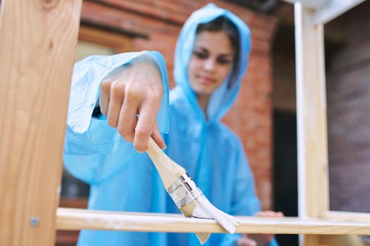 cheerful woman house painter repairing wooden structure. High quality photo