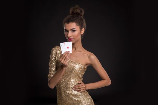 Pretty african girl shows two aces in casino poker and win Young woman in studio on black background
