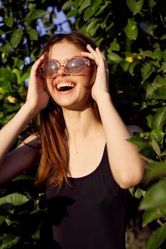 cheerful woman in black swimsuit green leaves nature posing. High quality photo