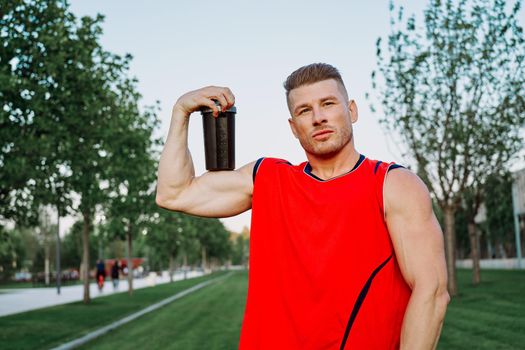 sporty man in the park outdoors glass with drink. High quality photo