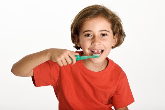 Happy little girl brushing her teeth with a toothbrush isolated on white background. Studio shot.
