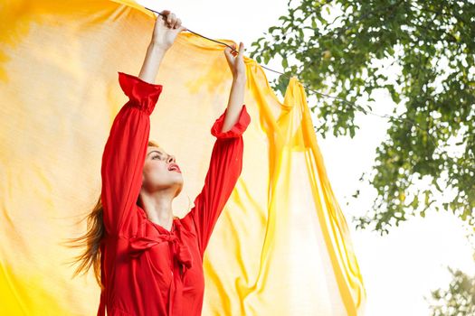 woman in red dress outdoors yellow bedspread. High quality photo