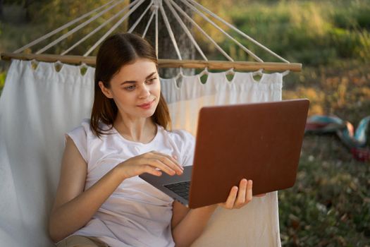 woman with laptop and lies in a hammock vacation nature freelance. High quality photo