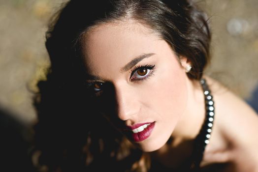 Portrait of pretty girl with long hair wearing black clothes in a park