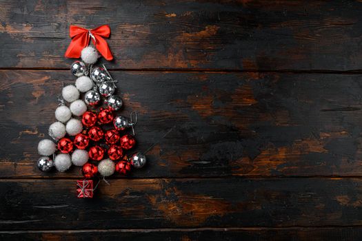 Christmas tree laid out on from toys set, on old dark wooden table background, top view flat lay, with copy space for text