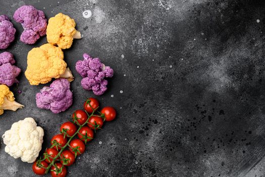 Purple yellow and white cauliflower set, on black dark stone table background, top view flat lay, with copy space for text