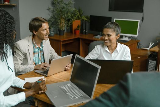 Ethnic group of business people meeting gathered to discuss ideas. Diverse group of business people gathered together for a startup. Teamwork concept.