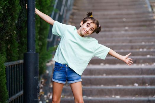Nine-year-old girl playing with a street lamp in a park