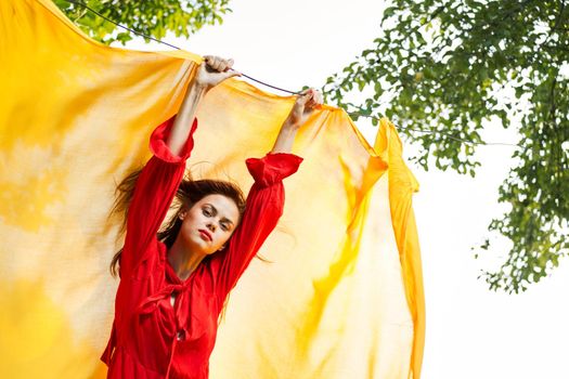 woman in red dress outdoors yellow bedspread. High quality photo