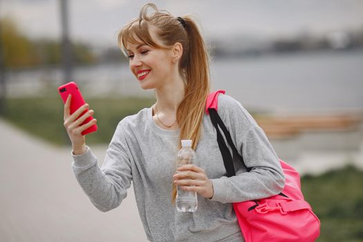 Beautiful girl training. Sports girl in a sportswear. Blonde by the water.