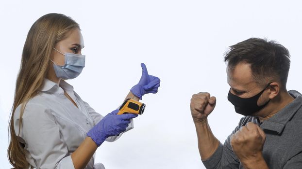 Happy patient after body temperature test using a non-contact thermometer nurse wearing a medical mask. Cheering happy man glad about of disease. Isolated on white background.