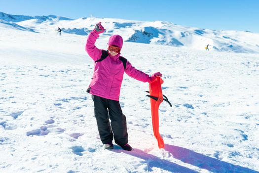 Little girl sledding at Sierra Nevada ski resort wearing snow clothes.