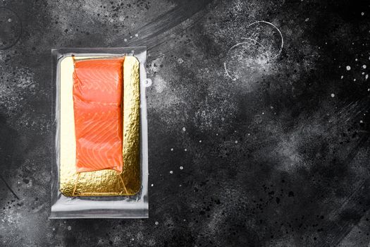 Salmon fillet vacuum pack fish meat set, on black dark stone table background, top view flat lay, with copy space for text