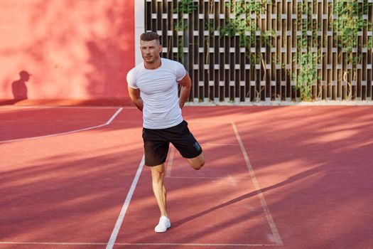 man in white t-shirt on the sports ground workout motivation. High quality photo