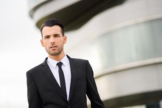 Portrait of a young businessman near a office building