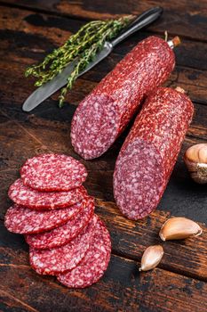 Sliced salami cured sausage on kitchen table. Wooden background. Top view.