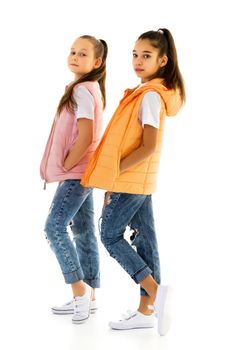 Two cute little girls in full growth, in the studio on a white background. The concept of a happy childhood, Beauty and fashion. Isolated.