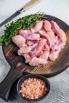 Sliced Raw Chicken breast fillet on a wooden cutting board. White background. Top view.