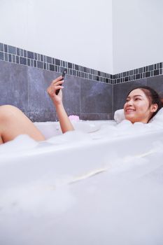 woman making selfie photo in bathtub in the bathroom