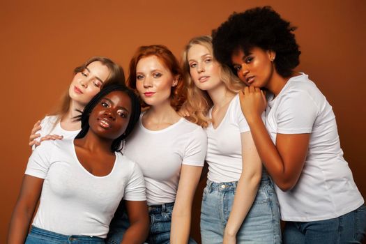 young pretty asian, caucasian, afro woman posing cheerful together on brown background, lifestyle diverse nationality people concept close up