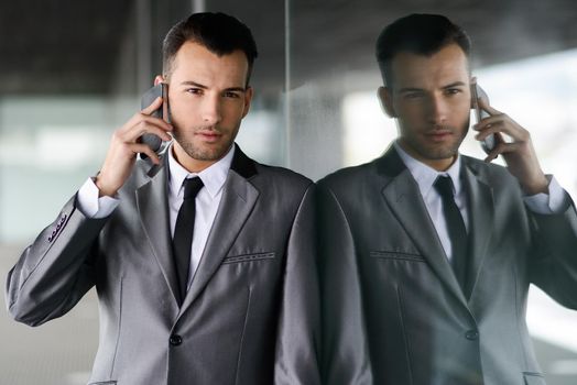 Portrait of an attractive young businessman on the phone in an office building