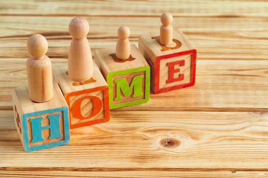 Wooden little family toys close up. House purchase, sale, rent concept