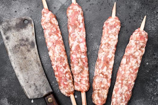 Minced and shaped lamb mutton kebabs set, on black dark stone table background, top view flat lay