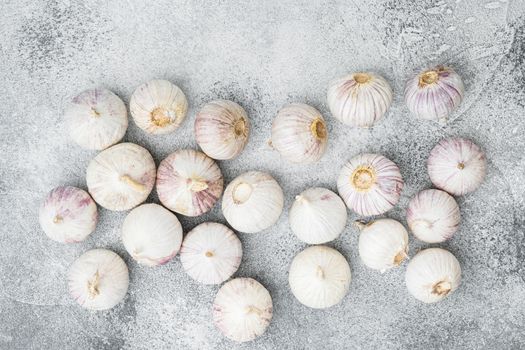 Small fresh garlic set, on gray stone table background, top view flat lay