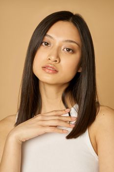 Close up portrait of stunning mixed race young woman with perfect skin looking at camera while posing isolated over light background. Female beauty portrait