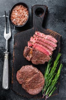 Fillet Mignon tenderloin Grilled and sliced meat beef steaks. Black background. Top view.