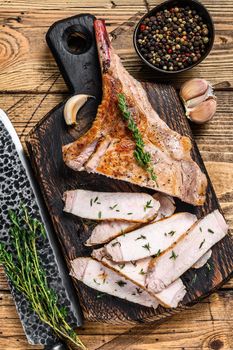 Sliced bbq rib pork chop meat steak. Wooden background. Top view.