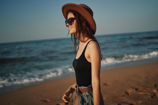 pretty woman in hat walking on the beach ocean travel. High quality photo
