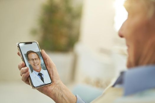 Cropped photo of old-aged man sitting at home and using mobile phone while having consultation with a therapist