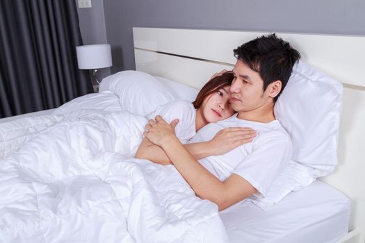 happy young attractive couple hugging on bed in the bedroom