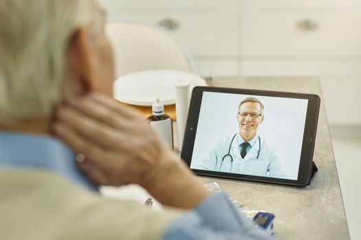 Cropped photo of sneior man looking at tablet screen with his doctor on the video-call