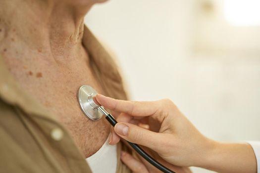 Fragment photo of a medical worker pressing a stethoscope to elderly man chest