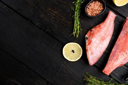Raw fish perch without a head set, on black wooden table background, top view flat lay, with copy space for text