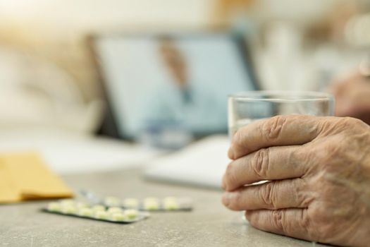 Copy-space photo of hand of a senior citizen holding a glass with water