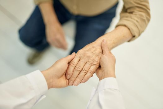 Cropped photo of a medical doctor checking hand function of a senior patient