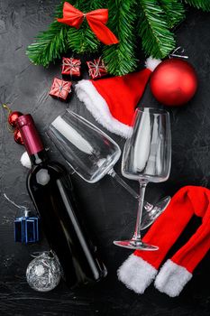 Bottles of wine Merry Christmas and a Happy New Year set, on black dark stone table background, top view flat lay