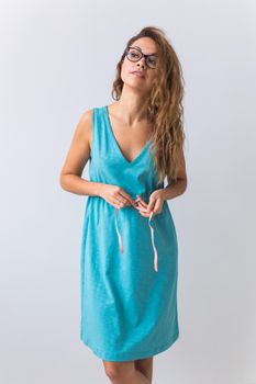 beautiful blond fashion model in blue dress and coral lips on white background.