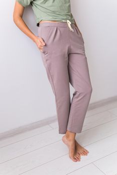Young attractive woman dressed in beautiful colorful pajama posing as a model in her living room. Comfortable sleepwear, home relaxation and female fashion concept