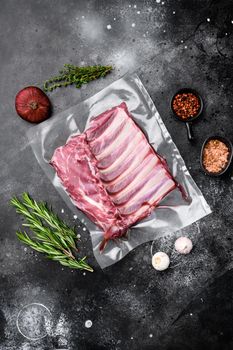 Racks of lamb meat rib fresh pack set, on black dark stone table background, top view flat lay, with copy space for text