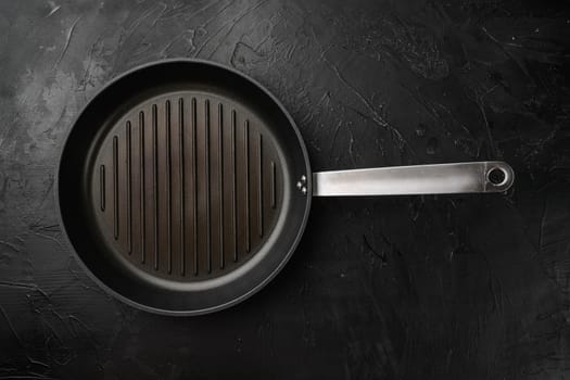 Black iron empty grill pan set with copy space for text or food with copy space for text or food, top view flat lay, on black dark stone table background