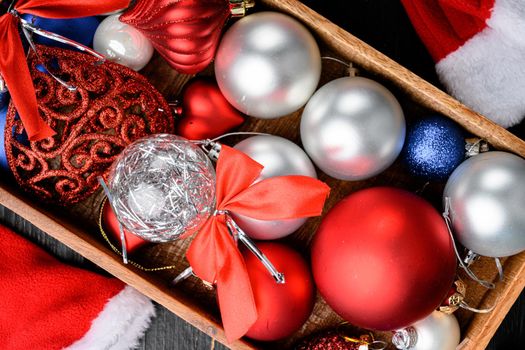 Christmas composition. Christmas gift, balls set, in wooden box, top view flat lay, on black wooden table background