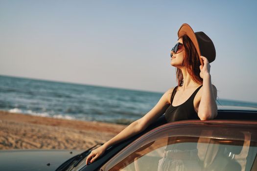 pretty woman in sunglasses near the car on the beach travel lifestyle. High quality photo